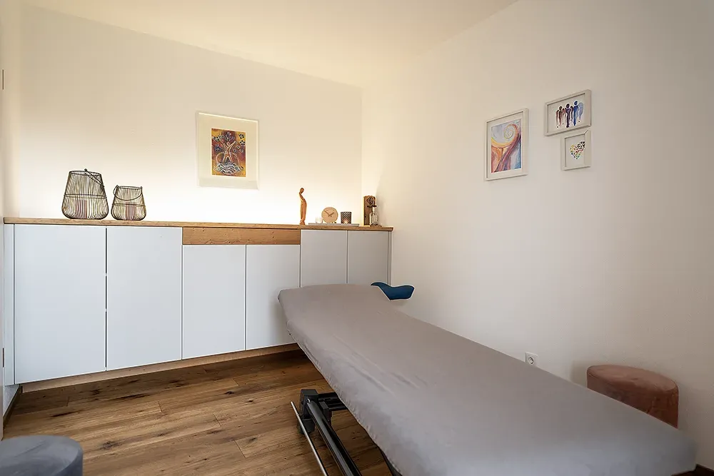 Behandlungsraum mit Therapieliege und warmem Licht