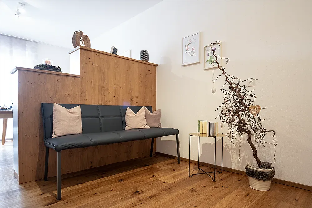 Wartebereich mit gemütlicher Sitzbank und Holzverkleidung